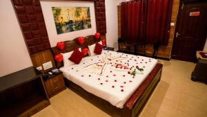 a bedroom with a bed with red decorations on it at Sakthi River Resort in Pollāchi