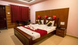 a bedroom with a bed with two swans on it at Sakthi River Resort in Pollāchi