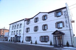 un edificio blanco con ventanas negras en una calle en Navi Home, en Pavlodar