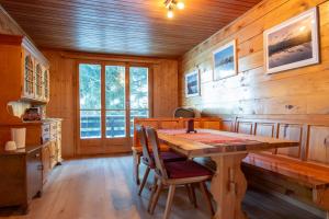 a dining room with a wooden table and chairs at Chalet Daheim - Ferienwohnung OG in Reckingen - Gluringen