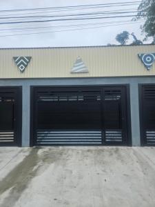 a garage with two garage doors on a building at Lofts 4 Elementos - Ar - Martim de Sá - Caraguatatuba in Caraguatatuba