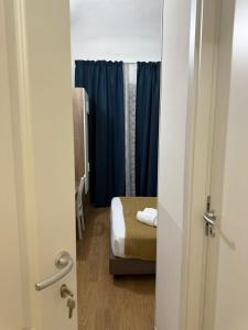 a door to a room with a bed and blue curtains at Conte GuestHouse in Rome