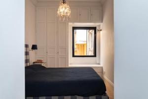 um quarto com uma cama, uma janela e um lustre em Terrazza segreta del Vaticano em Roma
