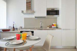 a white kitchen with a table with chairs and a sink at Classic Venice House 2 in Venice +33 photos