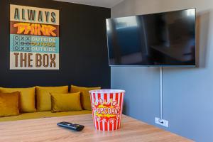 une tasse posée sur une table devant une télévision dans l'établissement KOA - THE BOX, à Braşov 40 autres photos