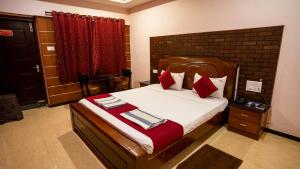 a bedroom with a large bed with red pillows at Sakthi River Resort in Pollāchi