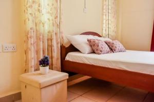 Un pequeño dormitorio con una cama y una olla en un taburete en Mi Casa Su Casa, en Mtwapa 37 fotos más