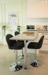 a kitchen with a table and two black chairs at Spacious One Bedroom Apartment in Caesar Resort & SPA, Long Beach in Perivolia tou Trikomou