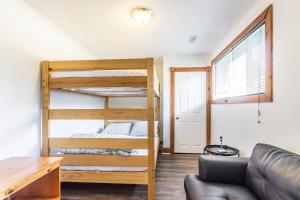 a room with bunk beds and a couch at Birch View- Balcony-Backyard-Parking-Sauna-Sleeps 20 in Blue Mountains