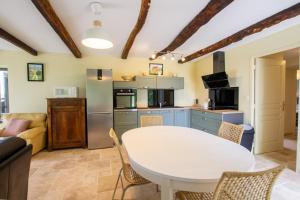 una cucina e un soggiorno con tavolo e sedie di Le moulin a vent a Nailhac