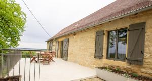 una casa con balcone arredato con tavolo e sedie di Le moulin a vent a Nailhac