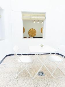 un tavolo bianco e sedie in una stanza con una finestra di APARTAMENTO COMPLETO con PATIO y TERRAZA - EL CARPIO CENTRO - CORDOBA - WiFi a El Carpio Altre 14 foto