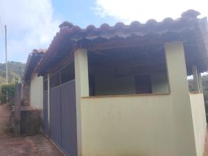 ein weißes Gebäude mit einem Tor davor in der Unterkunft Casa da Betania em Ibitipoca in Conceição da Ibitipoca