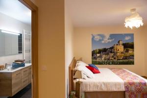 a bedroom with a bed and a painting on the wall at Le fort in La Roque-Gageac +33 photos
