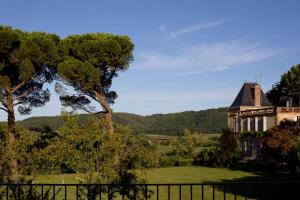 a house in a field with trees and a fence at Le fort in La Roque-Gageac