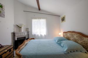 Un dormitorio con una cama con sábanas azules y una chimenea. en La pergola, en Bergerac