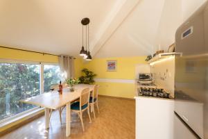 eine Küche mit einem Holztisch und eine Küche mit gelben Wänden in der Unterkunft Apartmant with Pool 8 in Kaštela