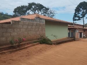 ein Haus mit Ziegelwand neben einer unbefestigten Straße in der Unterkunft Casa da Betania em Ibitipoca in Conceição da Ibitipoca