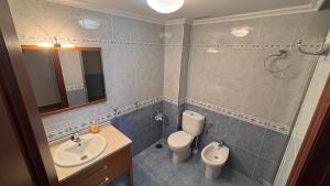 a bathroom with a sink and a toilet and a mirror at Casa Frijol 20metres from the beach in Los Alcázares