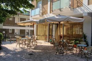 un patio al aire libre con mesas, sillas y sombrillas en Sporting hotel, en Gabicce Mare