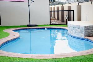 a swimming pool in a yard with a fence at Ken Koral Bed and Breakfast in Gaborone +10 photos