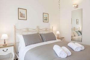 a bedroom with a large white bed with towels on it at Donna Margherita Rome Suite & Rooms in Rome
