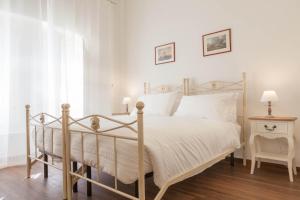 1 dormitorio con 1 cama blanca y 1 silla en Donna Margherita Rome Suite & Rooms, en Roma