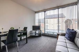 a living room with a couch and a desk with a television at Charming 1-bed Flat in Eastwood in Eastwood