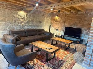 a living room with a couch and a table at Villa The Old School Plana with Hot Pool & SPA by BookVillaBG in Plana