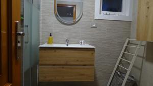 a bathroom with a sink and a mirror at Ático en la Playa de Cangas in Cangas de Morrazo