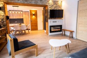a living room with a fireplace and a dining room at Superbe vue, accès skis aux pieds, très agréable in Courchevel