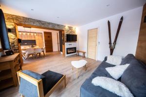 a living room with a blue couch and a table at Superbe vue, accès skis aux pieds, très agréable in Courchevel