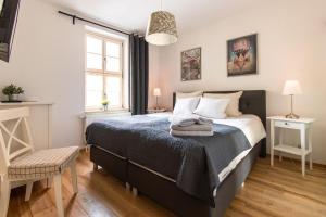 a bedroom with a bed and a chair and a window at Apartmenthaus Mathilde in Quedlinburg