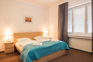 1 dormitorio con 1 cama con 2 toallas en Petit Dependance, en Bratislava