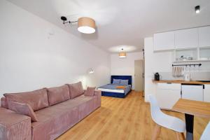 a living room and kitchen with a couch and a table at Być Morze in Pobierowo