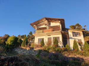 une maison au sommet d'une colline dans l'établissement Yogi Greenwood Cottage, à Mukteswar