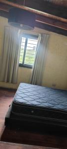 a bed in a room with a window at Cabaña el diquecito in La Calera