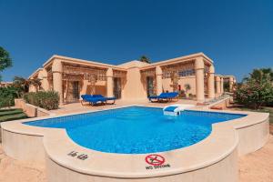 a swimming pool in front of a house at Sheraton Soma Bay Resort in Hurghada