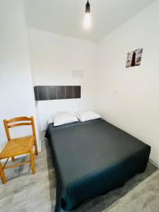 un dormitorio con una cama y una silla en Hotel Le Breton, en Indret