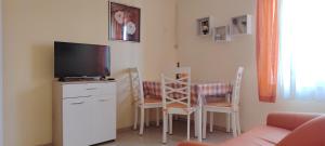 sala de estar con TV y mesa con sillas en Apartments Mara, en Mali Lošinj