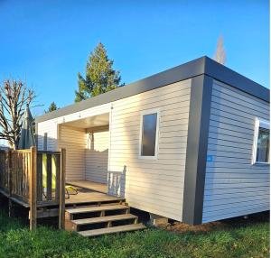 a tiny house with a wooden staircase in the yard at Camping de Charlieu in Charlieu
