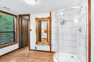 een badkamer met een douche en een spiegel bij Clutter Falls Retreat - Guest House in New Braunfels +22 foto's