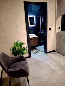 a bathroom with a shower and a chair and a sink at Matilde Valletta Suites in Valletta