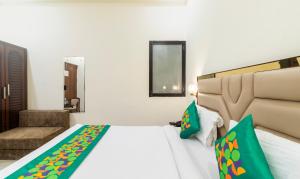 ein Hotelzimmer mit einem Bett und einem Stuhl in der Unterkunft Treebo Brij Kaushal, Near Prem Mandir in Vrindāvan