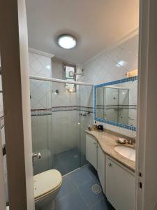 une salle de bains avec douche, toilettes et lavabo dans l'établissement Apartamento Pé na Areia Guarujá Pitangueiras, à Guarujá