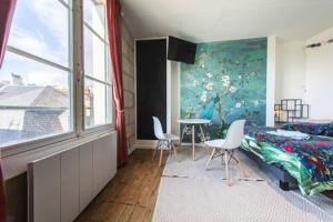 Un dormitorio con una cama y una mesa y sillas. en Le petit Leon - CENTRE Chinon - idéal CNPE, en Chinon