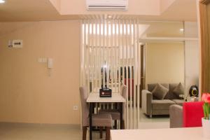 芝卡朗Cozy and Comfort Living 1BR at Oasis Cikarang Apartment By Travelio的客厅里有一张桌子和一张沙发