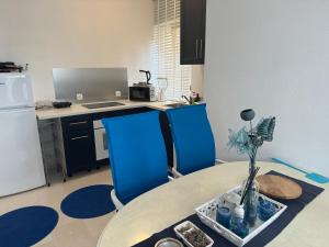 a kitchen with a table and two blue chairs at Villa Sunshine in Orebić