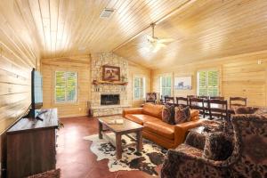 a living room with a couch and a fireplace at Wimberley Log Cabins Resort and Suites- The Oak Lodge in Wimberley