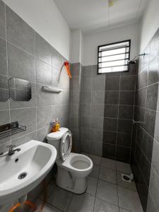 a bathroom with a white toilet and a sink at Homestay Farrell Seremban in Seremban